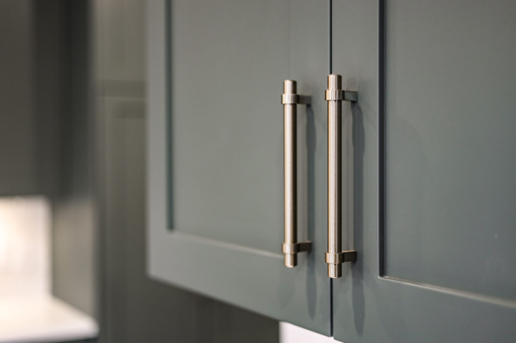 Modern grey-green cabinetry with stylish silver hardware